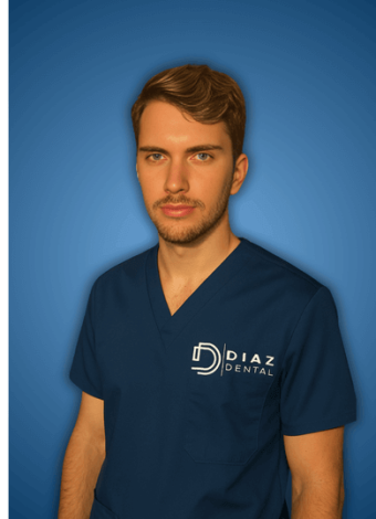Un joven con uniforme azul marino y el logotipo de Diaz Dental sobre un fondo azul degradado mira a la cámara con expresión neutra.